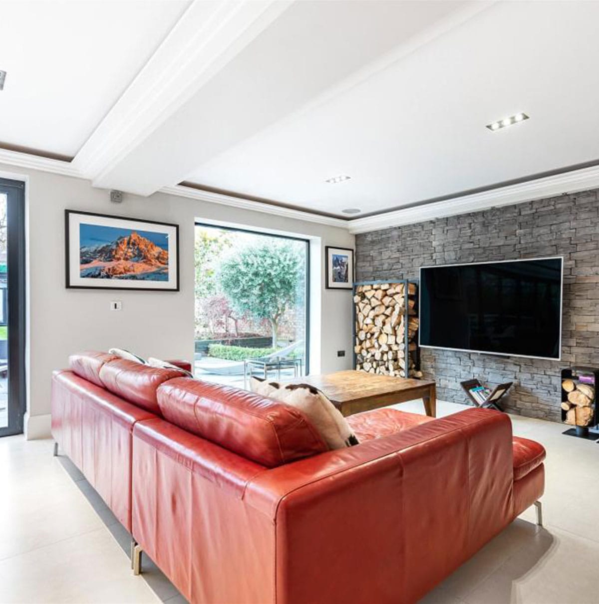 Interior living room with a red sofa and wall mounted TV
